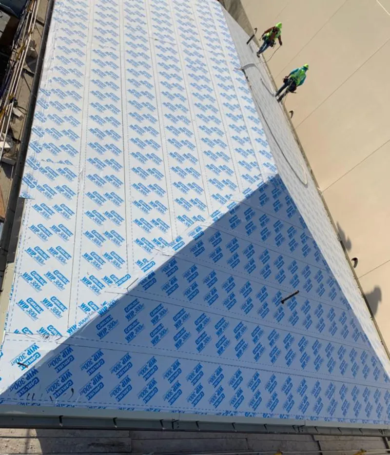 Professional roofers installing underlayment on a metal roof in Keene